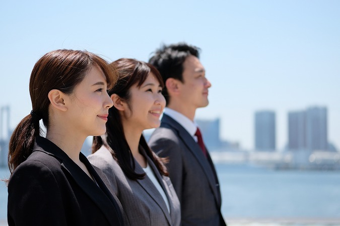 スーツで並ぶ男女3人